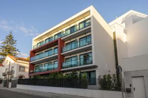 an apartment building with balconies on a street at Hotel Alvorada in Estoril