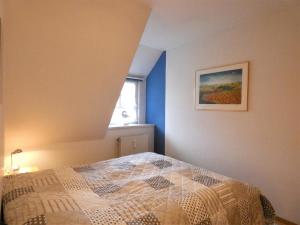 una camera da letto con un letto e un quadro sul muro di Lüttje Koog Whg8 a Boldixum