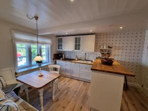 a kitchen with white cabinets and a wooden table at Hüs Lorenzen in Oevenum +11 photos