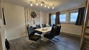 a dining room with a table and black chairs at Haus Ilse Wohnung 9 in Sankt Andreasberg