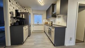 a kitchen with black and white cabinets and a window at Haus Ilse Wohnung 9 in Sankt Andreasberg +23 photos