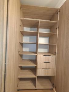 a closet with wooden shelves in a room at House in the City Center 1 piętro in Przemyśl