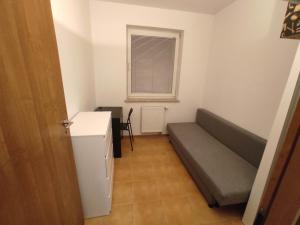 a small room with a couch and a window at Nice room with 2 shared bathrooms ,WC , 2km to old town -100m from Metro Szwedzka in Warsaw +8 photos