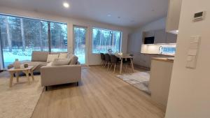a living room and kitchen with a couch and a table at Villa Tervas, Arctic circle in Rovaniemi