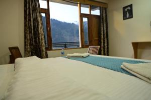 Postelja oz. postelje v sobi nastanitve Krishana Cottage A Pure Veg !!!300 m From Hadimba Temple!!!Balcony Rooms!!!Veg Restaurant!!!Couple Friendly!!!Family Cottage!!!