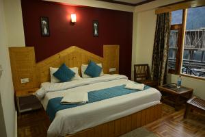 Postelja oz. postelje v sobi nastanitve Krishana Cottage A Pure Veg !!!300 m From Hadimba Temple!!!Balcony Rooms!!!Veg Restaurant!!!Couple Friendly!!!Family Cottage!!!