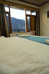 Postelja oz. postelje v sobi nastanitve Krishana Cottage A Pure Veg !!!300 m From Hadimba Temple!!!Balcony Rooms!!!Veg Restaurant!!!Couple Friendly!!!Family Cottage!!!