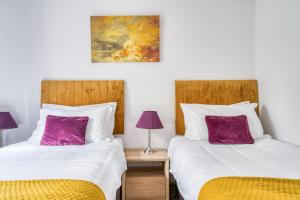 two beds sitting next to each other in a bedroom at Luxury Cottage in New Forest Perfect for Family and Friends in Redlynch +10 photos