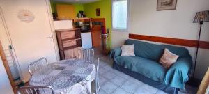un soggiorno con un divano blu e un tavolo di La Maisonnette a Béziers