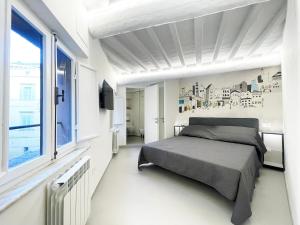una camera da letto bianca con un letto e una finestra di Il Nido vicino Piazza del Campo a Siena