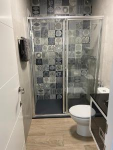 un bagno con doccia e WC di Apartamentos turísticos ilusiones a Cazalla de la Sierra Altre 24 foto