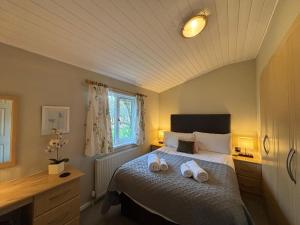 a bedroom with a bed with two towels on it at Churchill Lodge in Kingham