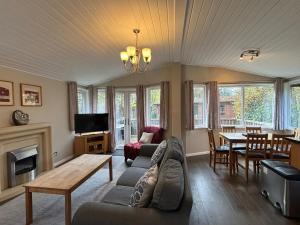 a living room with a couch and a table at Churchill Lodge in Kingham
