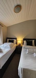 two beds sitting next to each other in a room at Churchill Lodge in Kingham