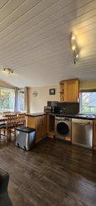a kitchen with a stove and a table and chairs at Churchill Lodge in Kingham