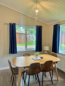 a dining room with a wooden table and chairs at Churchill Lodge in Kingham