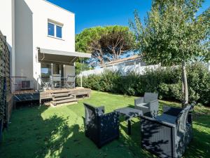 a yard with chairs and a house at La Dune 32 - Villa 2P4 in Sérignan