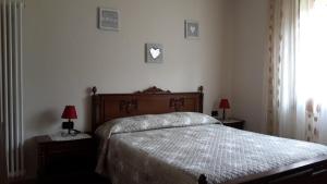 a bedroom with a bed with two lamps and a window at Casa Ferrari Michela in Calceranica al Lago