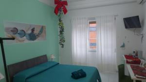 a bedroom with a blue bed and a window at Sul Serio in Salerno