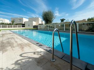 a swimming pool with metal rails next to a building at La Dune 22 - Villa 2P4 in Sérignan