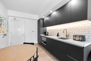 a kitchen with black cabinets and a wooden table at Luxury One-Bedroom w Top Amenities! in Miami