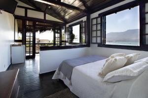 a bedroom with a bed with a view of the ocean at Pousada Kaya in São Sebastião