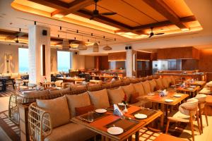 Un restaurante con mesas y sillas en una sala. en Swosti Premium Beach Resorts, Puri, en Puri