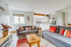 a living room with a couch and a table at Luxury Cottage in New Forest Perfect for Family and Friends in Redlynch