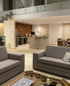 a living room with two couches and a kitchen at Casa Tullpa in Aspitia