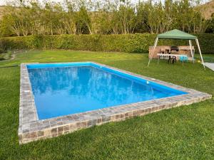 a swimming pool in a yard with a table and a tent at Casa Tullpa in Azpitia