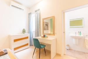 Is-SwieqiLarge apartment with pool的一间带书桌和绿色椅子的浴室