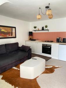 een woonkamer met een zwarte bank en een witte salontafel bij Le Charmant in Lannion