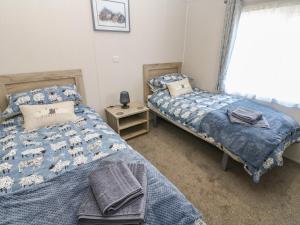 a bedroom with two beds and a window at Brocklebank Lodge, 35 in Carlisle
