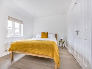 チチェスターにあるCharming Coastal Home with Garden Pass The Keysの白いベッドルーム(黄色い毛布付きのベッド付)