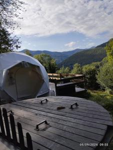 a wooden table with birds on it with a tent at Dôme de l'Arriou in Ourde +10 photos