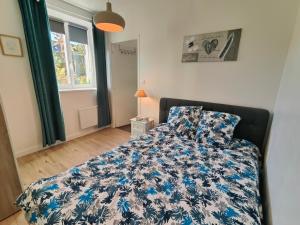 sypialnia z łóżkiem z niebiesko-białą kołdrą w obiekcie Calm and Cosy w Saint-Malo