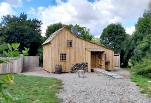 une grande grange en bois installée dans une cour dans l'établissement The country House 56, à Campénéac