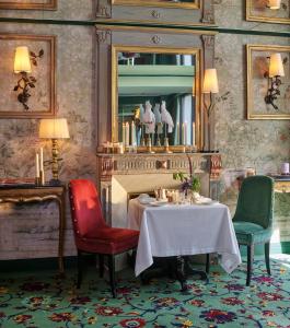 a dining room with a table and two chairs and a mirror at Maison Barnes Paris Trocadero in Paris