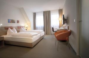 a hotel room with a bed and a desk at Hotel am Jakobsmarkt in Nuremberg