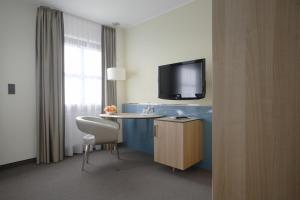 a hotel room with a table and a tv at Hotel am Jakobsmarkt in Nuremberg