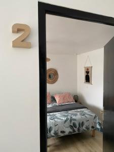 a bedroom with a bed and a mirror at Le Coquet in Lannion