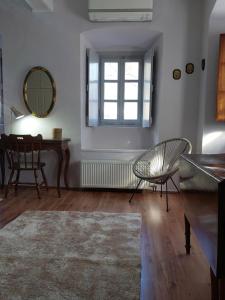 a room with a table and a chair and a mirror at Erika's home in Leonidio