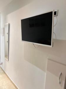 a flat screen tv hanging on a white wall at Apartamento acogedor en primera línea de playa in La Pineda