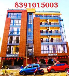 KalyaniN B Sonar Bangla Hotel的两辆车停在大楼前的建筑物