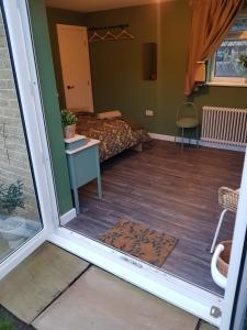 a view of a room with a bed and a door at Farsley guest room seperate entrance with double bedroom and private shower room in Farsley