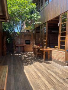 an outdoor patio with a wooden table and chairs at Pousada Quatro Estrelas in Penha