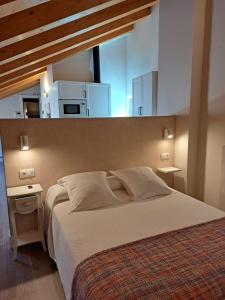 a bedroom with a large bed with a window above it at La Rua 25 in Castro-Urdiales