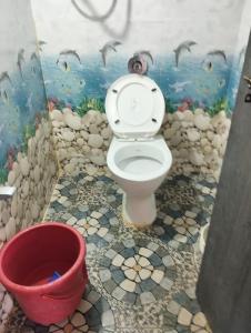 La salle de bains est pourvue de toilettes et d'une peinture murale. dans l'établissement Sanjay Homestay New Hampi, à Hampi