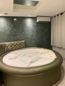a circular bed in a room with a wall at Caribe Palace Hotel Samambaia Sul in Brasilia
