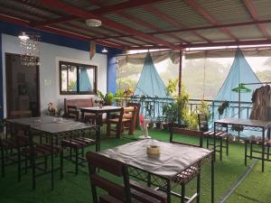a restaurant with tables and chairs and a balcony at Marbeth Inn in Coron